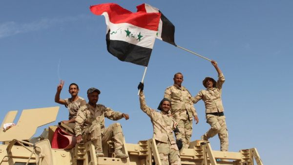 Iraqi government forces wave their national flags on March 10, 2016 after retaking the town of Zankura, northwest of Ramadi, from Daesh in Anbar province. (AFP/Moadh al-Dulami)