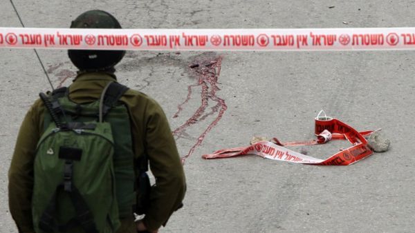 Blood stains from the body of a Palestinian assailant who was allegedly shot in the head by an Israeli soldier as he lay wounded on the ground after injuring an Israeli soldier with a fellow Palestinian attacker in a stabbing assault, stain the ground on March 24, 2016. (AFP/Hazem Bader)