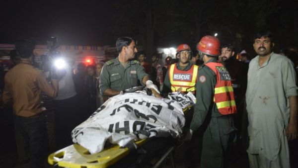 Pakistani rescuers use a stretcher to shift a body from a bomb blast site in Lahore on March 27, 2016. (AFP/Arif Ali)
