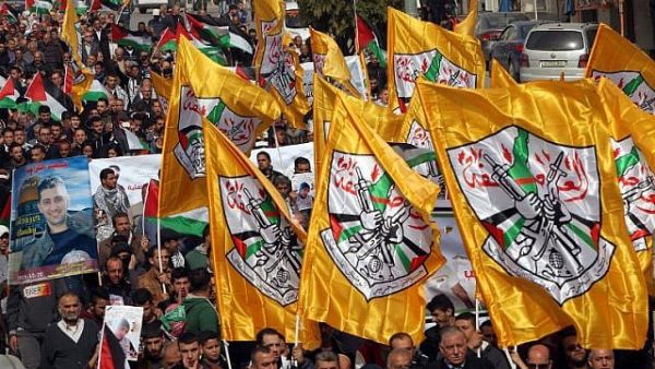 Palestinian demonstrators hold Fatah party flags as they demonstrate in the center of the West Bank city of Hebron. (AFP/HAZEM BADER)
