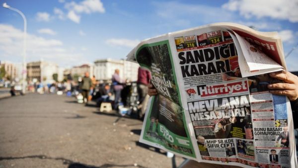 A Turkish man reads a newspaper on Galata Bridge in Istanbul on November 2, 2015, a day after the country's general election. (AFP/Ozan Kose)