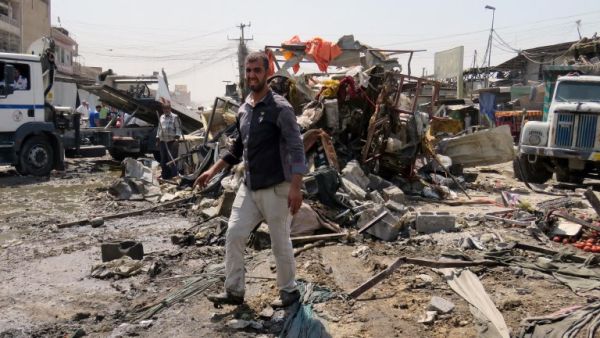 Iraqis look at the damage following a car bomb explosion in Baghdad's Shiite-majority district of Sadr City on August 28, 2017. Security sources said the bombing killed 11 people and wounded another 26. (AFP)