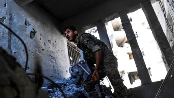 An SDF fighter looks out from a ruined building in Raqqa, AFP 
