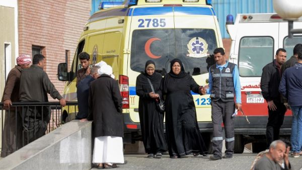 Relatives of the victims of the bomb and gun assault on the North Sinai Rawda mosque walk past an ambulance while waiting outside the Suez Canal University hospital. (AFP)