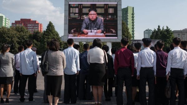 Spectators listen to a television news broadcast of a statement by North Korean leader Kim Jong-Un, before a public television screen outside the central railway station in Pyongyang on Sept. 22, 2017 (Ed JONES/AFP)