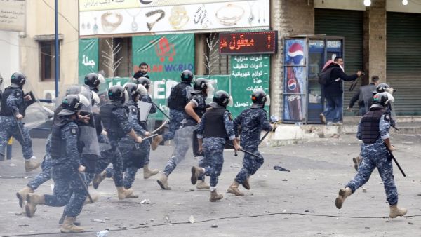 Lebanese security forces run after protestors during a demonstration outside the US embassy in Awkar, on the outskirts of the Lebanese capital Beirut, on Dec. 10, 2017, to protest against Washington's decision to recognize Jerusalem as the capital of Israel (ANWAR AMRO/AFP)