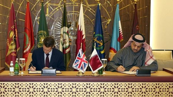 Qatar's Defense Minister Khalid bin Mohammed al-Attiyah (R) signs an agreement with his British counterpart Gavin Williamson to buy 24 Typhoon fighters from the U.K., in the capital Doha on Dec. 10, 2017 (Stringer/AFP)
