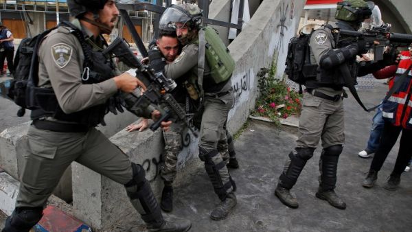Israeli border guards detain a Palestinian man (L) during clashes with Palestinian protesters north of Ramallah in the Israeli occupied West Bank, on Dec. 22, 2017 (ABBAS MOMANI / AFP)