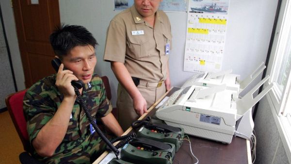 This file photo taken on Aug. 10, 2005 shows South Korean Lieutenant Choi Don-Rim (L) communicating with a North Korean officer during a phone call at a military office as the two countries tested a hotline aimed at helping avoid naval confrontations in the Yellow Sea (AFP/File)
