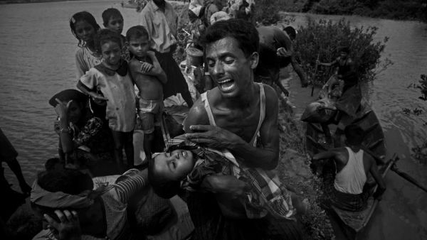 A Rohingya refugee reacts while holding his dead son after crossing the Naf river from Myanmar into Bangladesh in Whaikhyang on Oct. 9, 2017 (INDRANIL MUKHERJEE / AFP)