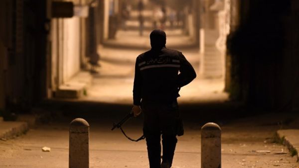 A member of the Tunisian security forces stands across protesters during clashes in the Ettadhamen on the outskirts of Tunis late on Jan. 10, 2018 (FETHI BELAID / AFP)
