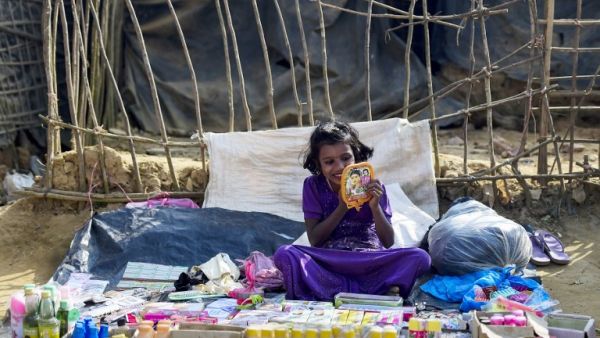 A Rohingya Muslim refugee applies lipstick as she waits for customers at a stall in Kutupalong refugee camp in Bangladesh's Ukhia district on Jan. 12, 2018 (Munir UZ ZAMAN / AFP)