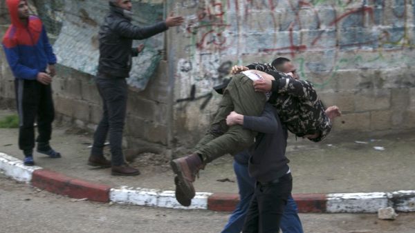 Palestinian youths evacuate a wounded comrade during clashes with Israeli forces in Jenin, in the north of the occupied West Bank, on Jan. 18, 2018 (JAAFAR ASHTIYEH / AFP)