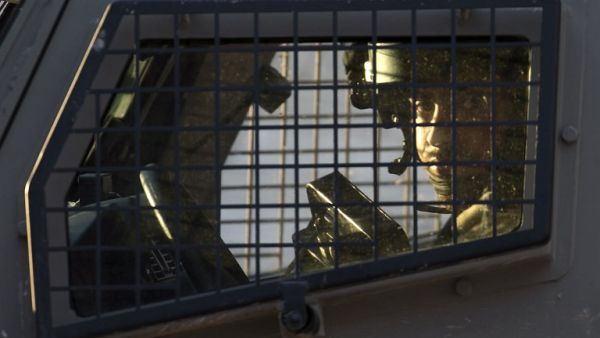 A member of the Israeli forces is seen inside a vehicle during a military operation in Jenin, in the north of the occupied West Bank, on January 18, 2018. A Palestinian was killed during clashes with Israeli forces in Jenin, the Palestinian health ministry announced. Israel's Shin Beth security services said shots were fired during a raid by border guards to capture the alleged perpetrators of an attack earlier this month in which a rabbi was shot dead. 
(JAAFAR ASHTIYEH / AFP)