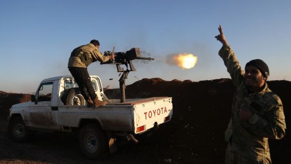 Turkish-backed fighters from the Free Syrian Army stand in the Tal Malid area, north of Aleppo, as they fire towards Kurdish People's Protection Units (YPG) positions in the village of Um al-Hosh, in the area of Afrin, on Jan. 20, 2018 (Nazeer al-Khatib / AFP)