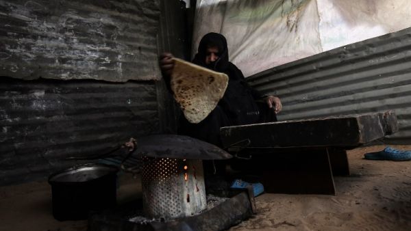 A Palestinian mother bakes bread in the Rafah refugee camp in the southern Gaza Strip on Jan. 24, 2018 (SAID KHATIB / AFP)