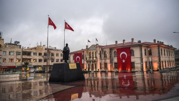 A municipality worker walks in front of a government building in the Turkish border province of Kilis on January 24, 2018. Rockets fired from Syria killed two people and wounded 11 others on January 24 in southern Turkey on the fifth day of Ankara's offensive against a Syrian Kurdish militia which President Recep Tayyip Erdogan vowed to eliminate.
(OZAN KOSE / AFP)