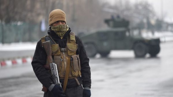 A member of an Afghan security detail guards the site of an ongoing attack near the Marshal Fahim Military Academy base in Kabul on Jan. 29, 2018 (WAKIL KOHSAR / AFP)
