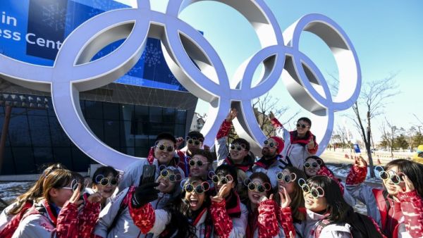 Pyeongchang Olympic volunteers pose for a photo next next to the Olympics rings ahead of the Pyeongchang 2018 Winter Olympic Games in Pyeongchang on Feb. 6, 2018 (Dimitar DILKOFF / AFP)