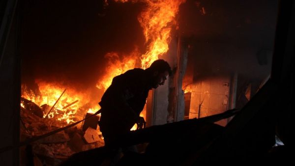 A Syrian man searches for people in a fire following regime air strikes on the rebel-held besieged town of Douma in the eastern Ghouta region, on the outskirts of the capital Damascus, on Feb. 7, 2018. 
(Hamza Al-Ajweh / AFP)