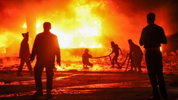 A picture taken on Feb. 7, 2018 shows Syrian civil defense volunteers attempting to put out a fire in the city of Maaret al-Numan in the rebel-held Idlib province, following reported regime air strikes (Amer ALHAMWE / AFP)