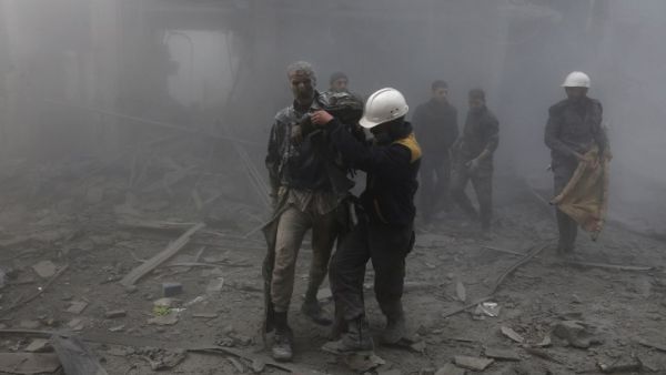 A wounded man is helped out of the destruction following air strikes in the rebel-held enclave of Arbin in the Eastern Ghouta near Damascus on Feb. 8, 2018 (ABDULMONAM EASSA / AFP)