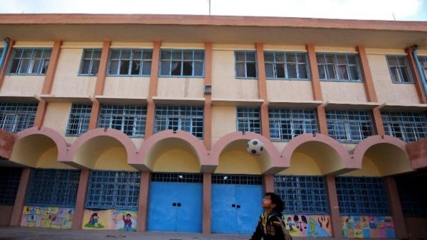 A child plays in front of a UNRWA-run school in Baqa'a camp, Jordan. (Khalil MAZRAAWI / AFP)
