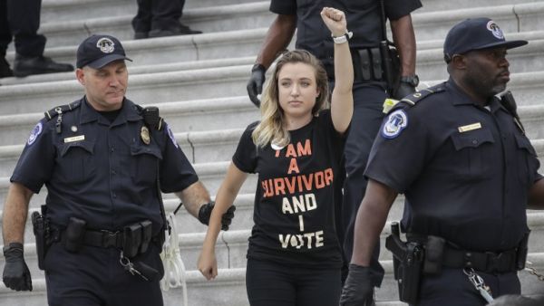 A protestor is arrested as demonstrators occupy the steps on the East Front of the U.S. Capitol in protest of Supreme Court nominee Judge Brett Kavanaugh, October 6, 2018 in Washington, DC (AFP)
