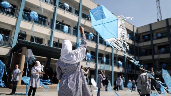 Palestinian schoolgirls fly kites outside their classrooms at a school belonging to the United Nations Relief and Works Agency for Palestinian Refugees (AFP/File Photo)