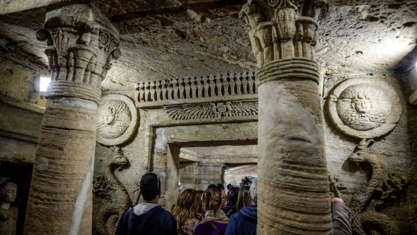 Visitors tour through the catacombs of Kom El-Shoqafa (Mound of Shards), dating to the Roman period (1st-4th centuries AD) in the centre of the Egyptian Mediterranean coastal city of Alexandria on March 3, 2019. (AFP/ File)