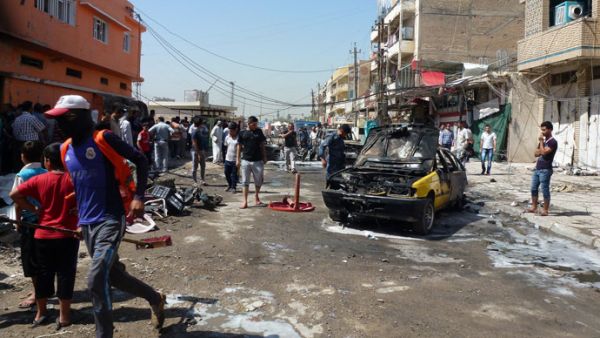 Iraqi civilians check the site of an explosion in Baghdad on August 28, 2013. (AFP/Sabah Arar) 