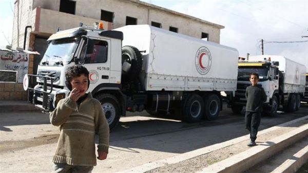 Syrian children walk in the street as a United Nations and Syrian Red Crescent inter-agency aid convoy arrives in the town of Utaya, in the militant-held enclave of Eastern Ghouta, Feb. 14, 2018 (AFP)