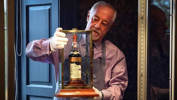 A Bonhams porter shows the bottle of Macallan Valerio Adamai 1926 whisky to packed auction house in Edinburgh today. The whisky was bottled in 1986 having been stored in a vat for 60 years previously (AFP)