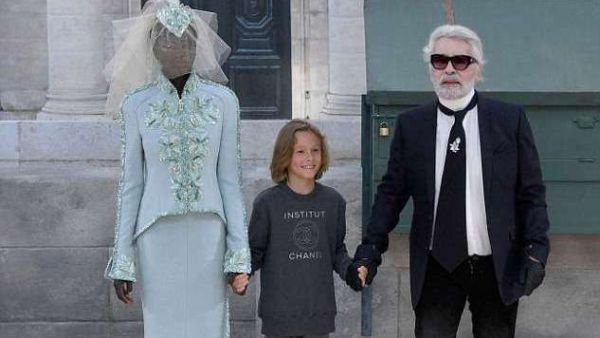 Adut Akech (pictured left alongside Karl Lagerfeld and his godson), 18, from Sudan has become only the second black model to walk the runway as the Chanel bride (AFP/File Photo)	