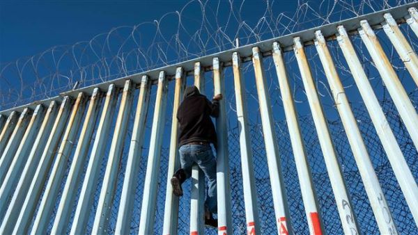 A Central American migrant that hopes to reach the United States, climbs the US-Mexico border fence in Playas de Tijuana, Baja California State, Mexico. (AFP/ File)