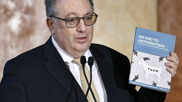 Ariel Muzicant, Vice-President of the European Jewish Congress, and co-author of the new document holds it up, showing the title 'An End to Antisemitism! A Catalogue of Policies to Combat Antisemitism' (AFP)