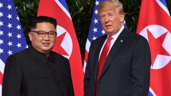 Standing in front of the flags of their two countries, Donald Trump and Kim Jong Un made history in Singapore (AFP /SAUL LOEB)
