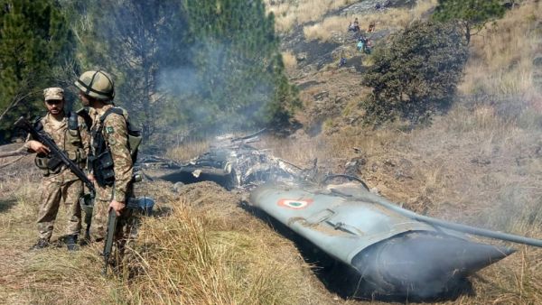 Pakistani soldiers stand next to what Islamabad says is the wreckage of an Indian fighter jet shot down in Pakistan- controlled Kashmir. (AFP/ File)