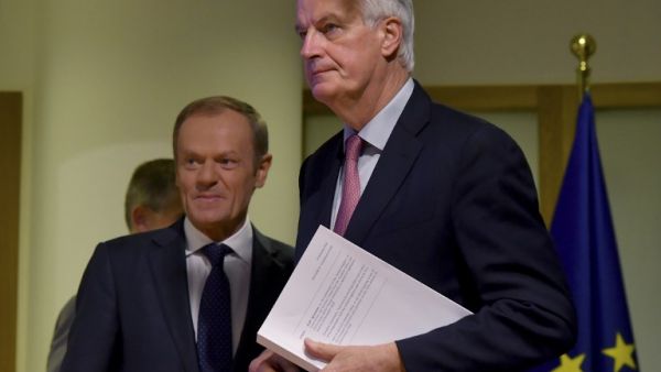 EU Brexit chief negociator Michel Barnier (R) holds the "draft agreement of the withdrawal of the United Kingdom of Great Britain and Northern Ireland from the European Union" while arriving with European Council President Donald Tusk for a press conference at the European Council in Brussels (AFP)