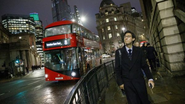 A red London bus makes it's way through the City of London (AFP)