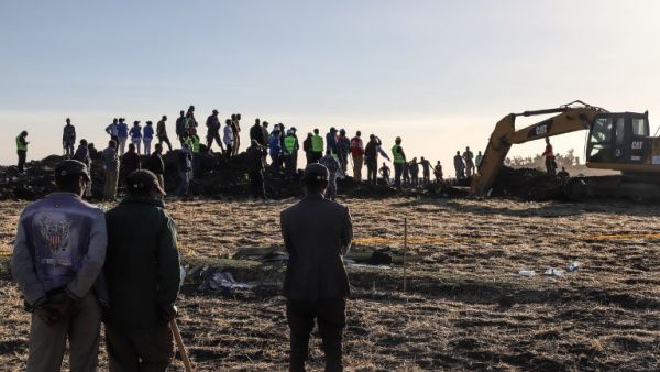 People watch workers at the crash site of a Nairobi-bound Ethiopian Airlines flight near Bishoftu (AFP)