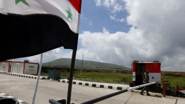 A member of the Syrian security forces walks near the border post with Israel in the Syrian town of Quneitra in the Golan Heights  (AFP)