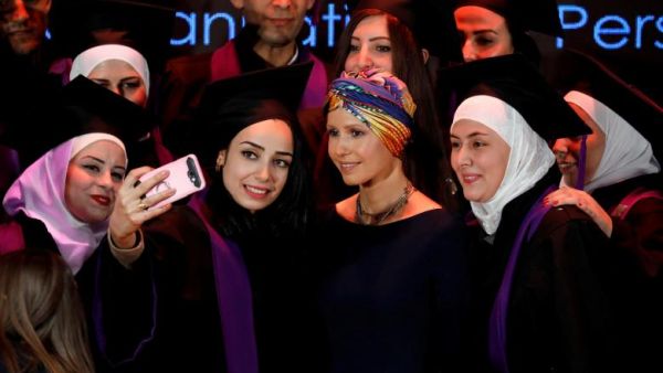Syria's First Lady Asma al-Assad (centre) poses for a picture during a graduation ceremony of future teachers of a Syrian Organisation for Persons with Disabilities, in Damascus yesterday (Twitter)