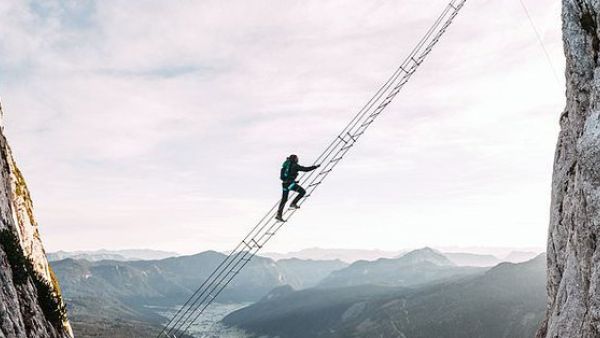 Daredevils scale wobbly ladder strung between two mountains  (Twitter)