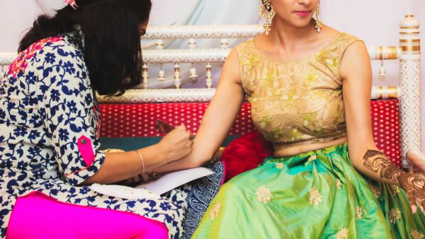 Indian Henna artist making a beautiful mehndi design on the hand (Shutterstock)