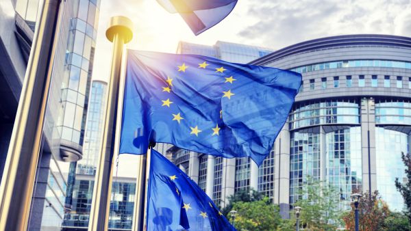 EU flags waving in front of European Parliament building (Shutterstock)