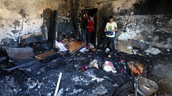 People survey the remains of the firebombed Dawabsha home in 2015. (AFP/File)