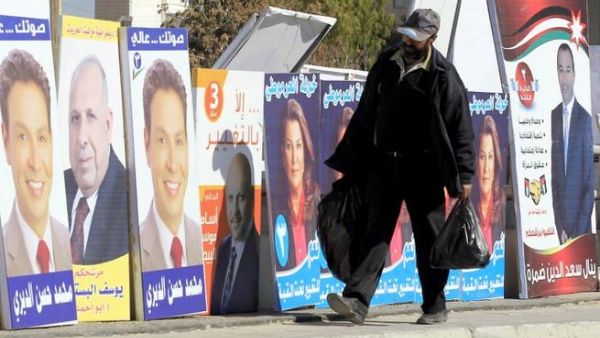 A Jordanian man walks past electoral campaign posters in Amman. (AFP PHOTO/KHALIL MAZRAAWI)