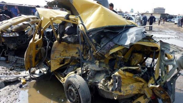A destroyed car lies at the scene of an explosion at the bird market in the north Baghdad Shia neighborhood of Kadhimiyah. (AFP PHOTO/ ALI AL-SAADI)