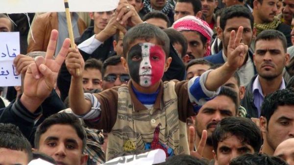 An Iraqi boy, whose face is made up with the national flag, flashes the sign of victory during a rally following the Friday's prayers to call for the government's fall. (AFP PHOTO/MARWAN IBRAHIM)